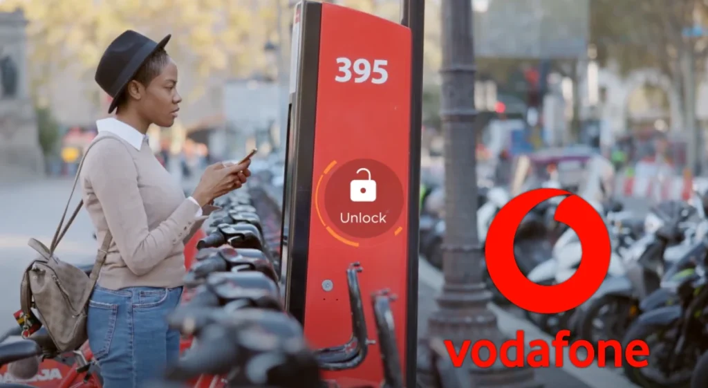 Young woman operating a bike hire terminal with her phone
